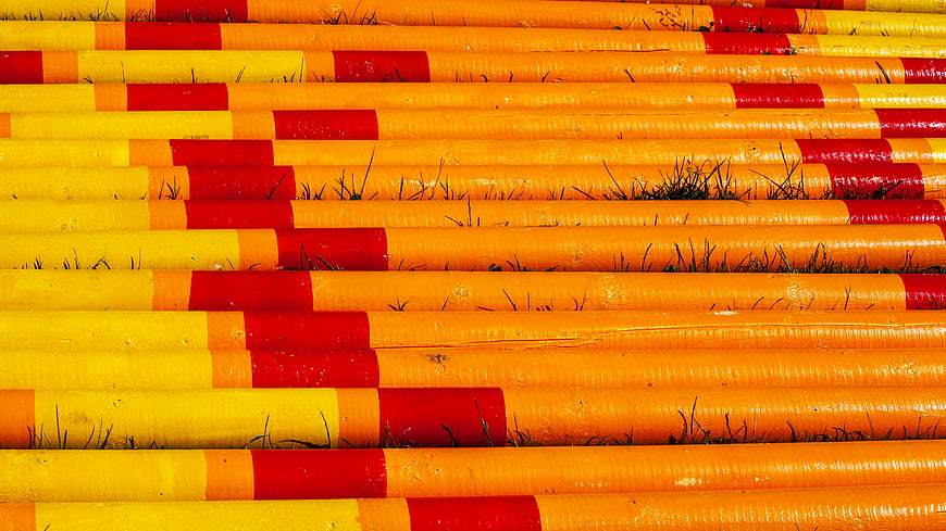 Colorful striped horse jump poles on grass background