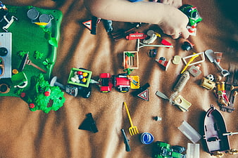 Top view of child playing with farm toys on bed