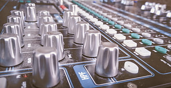 Close-up of professional audio mixing console knobs and sliders