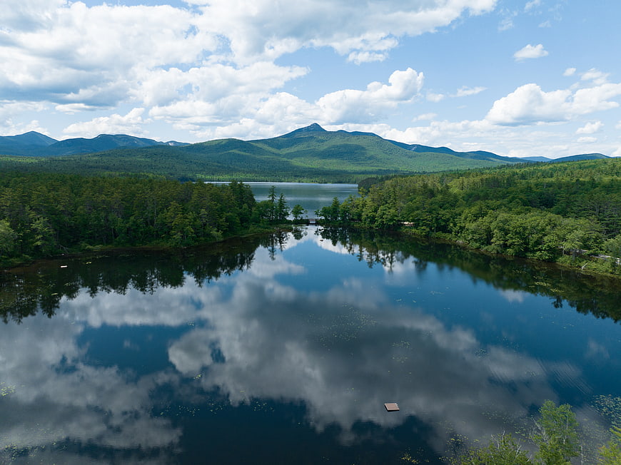 Serene Lake Reflection with Forest and Mountains