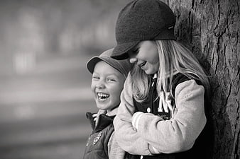 Laughing Boy and Girl Leaning Against Tree