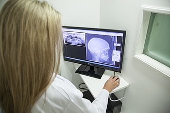 Dentist analyzing dental X-rays on computer monitor