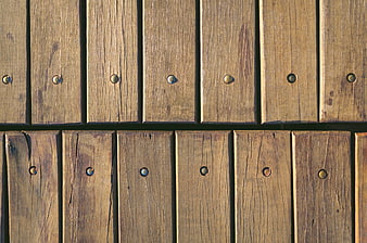 Close-up of weathered wooden planks with metal bolts