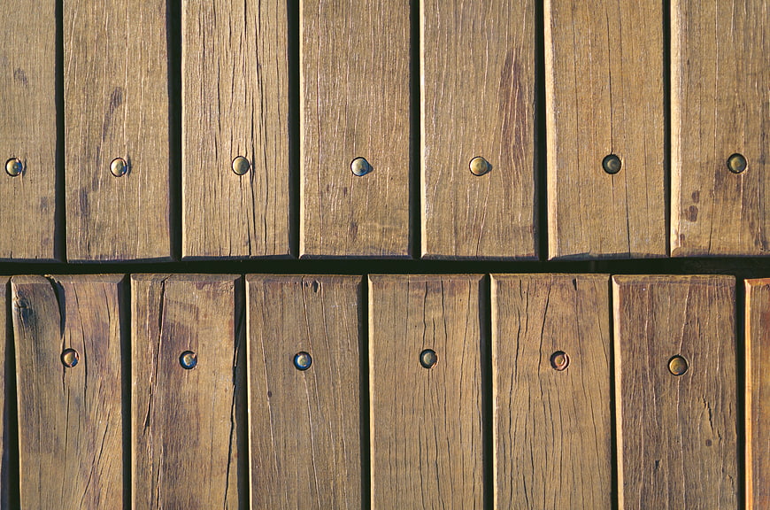 Close-up of weathered wooden planks with metal bolts