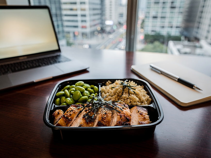 Healthy Grilled Chicken Quinoa Bento Lunch Box on Office Desk