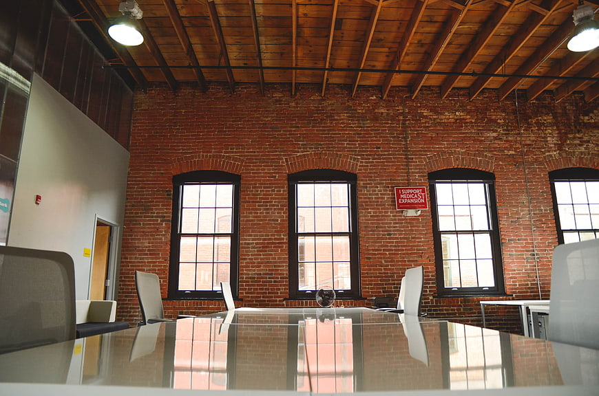 Modern Conference Room With Exposed Brick Walls And Wooden Beams