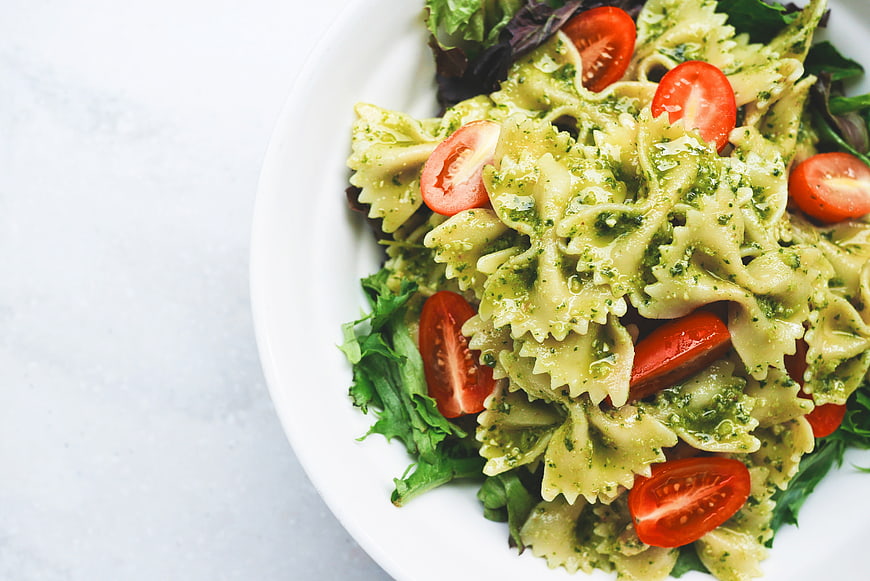 Pasta Salad with Pesto and Cherry Tomatoes on White Plate