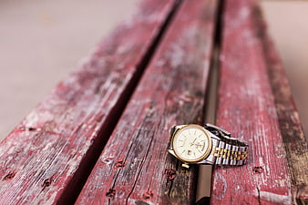 Vintage Gold Watch on Weathered Red Wooden Bench