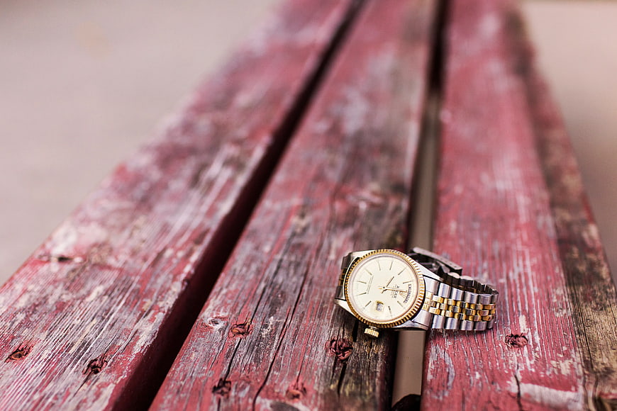 Vintage Gold Watch on Weathered Red Wooden Bench