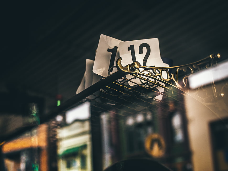 Close-up of table number 12 on ornate metal stand