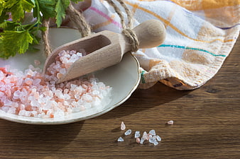 Himalayan Pink Salt Crystals with Wooden Scoop on Plate