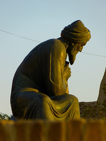 Bronze statue of Al-Khwarizmi seated in contemplation at dusk