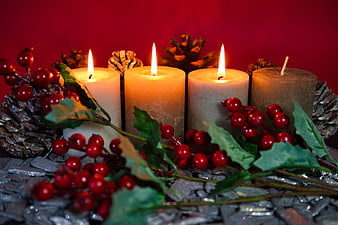 Advent Wreath With Candles, Pinecones, And Red Berries On Red Background