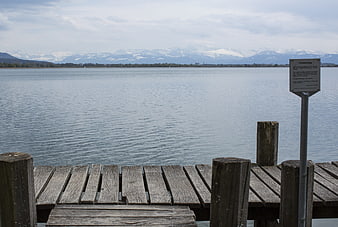 Wooden pier on Pfäffikersee with snow-capped Alps background