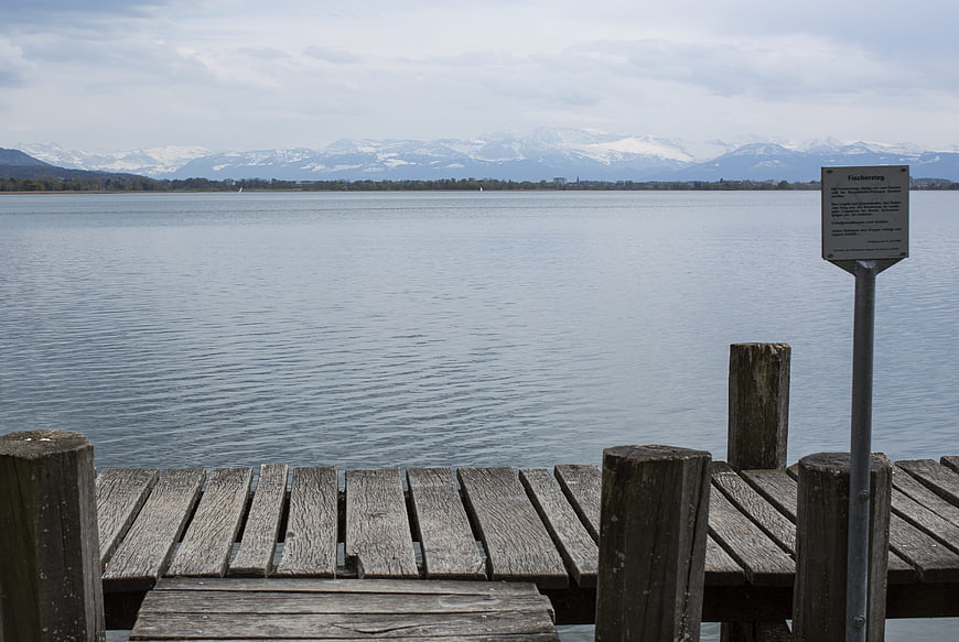 Wooden pier on Pfäffikersee with snow-capped Alps background