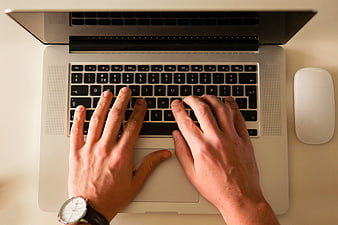Top View of Hands Typing on Laptop Keyboard with Watch