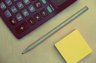 Red calculator, pen, and yellow sticky note on desk