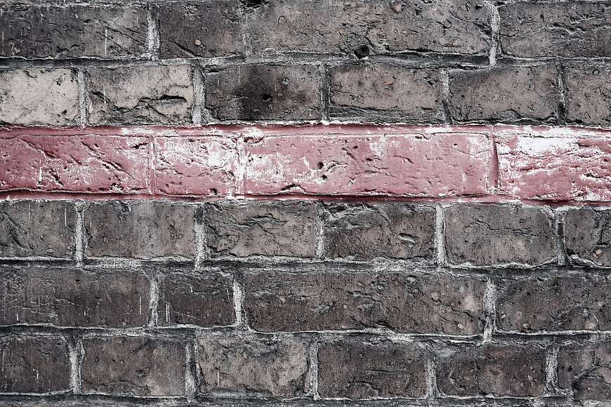 Textured Brick Wall with Distressed Red Paint Stripe