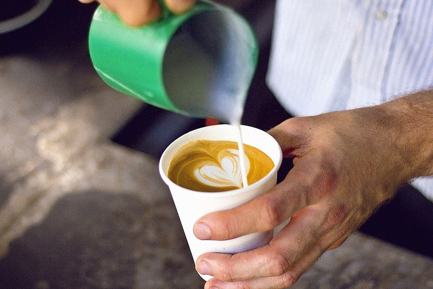 Barista Pouring Latte Art into Coffee Cup