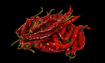 Pile of dried red chili peppers on black background