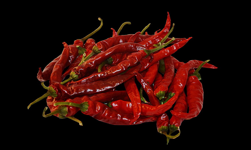 Pile of dried red chili peppers on black background
