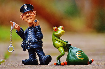 Police officer figurine arresting frog with euro money bag