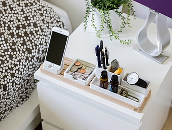 Organized white desk organizer with phone, coins, and pens
