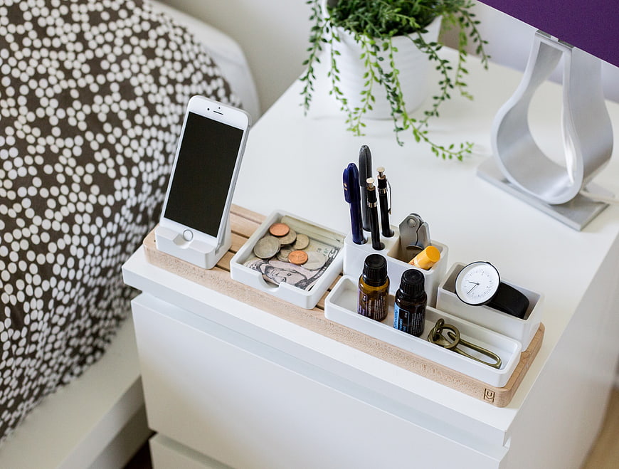 Organized white desk organizer with phone, coins, and pens