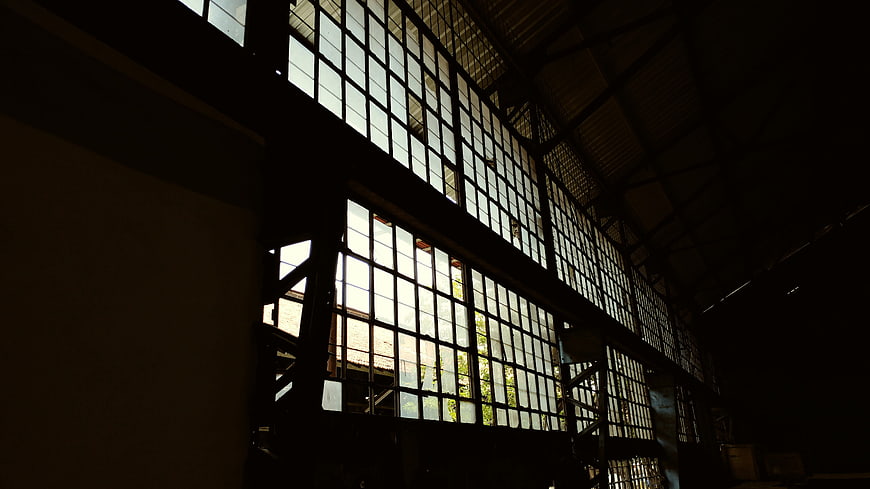 Dark Interior of Abandoned Industrial Building with Large Windows