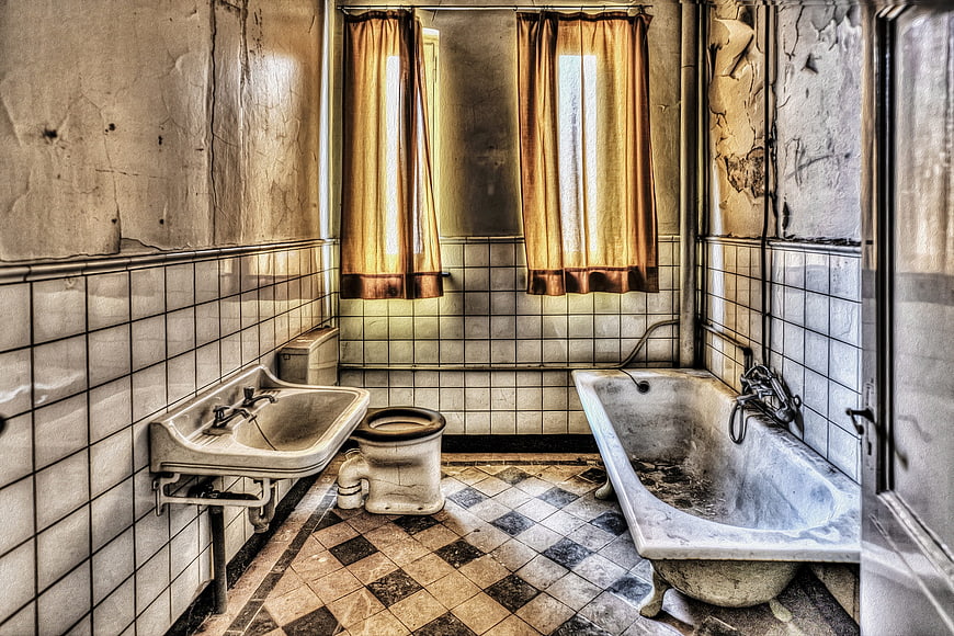 Abandoned vintage bathroom interior with peeling paint and decay