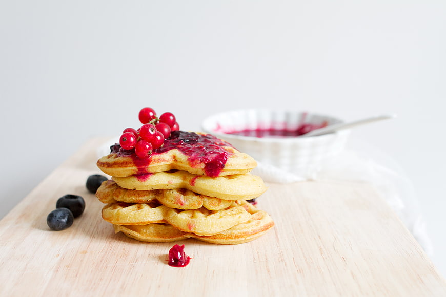 Stack of pancakes with berry sauce and fresh red currants