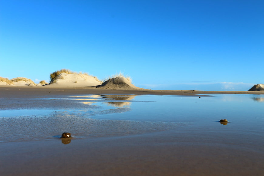 Serene Beach Landscape with Sand Dunes and Reflections