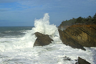 Powerful Ocean Wave Crashing Against Rocky Coastal Cliffs