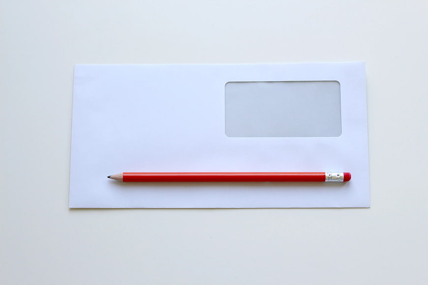 Red Pencil on White Window Envelope Flat Lay