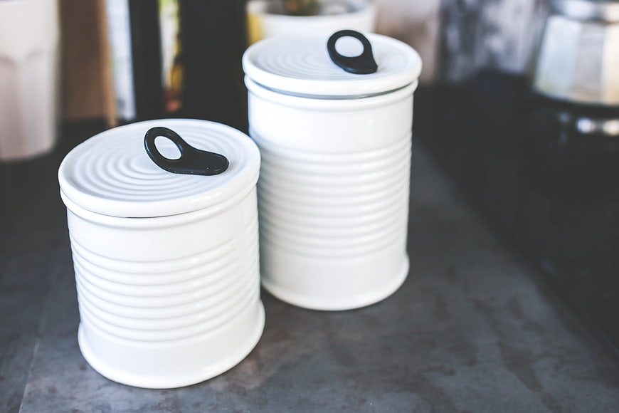 White ceramic kitchen canisters with black pull tabs