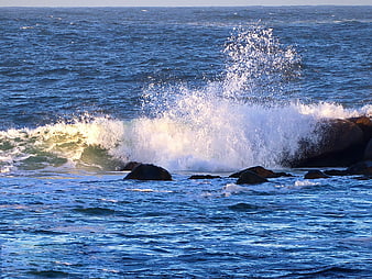 Powerful Ocean Wave Crashing Against Rocky Coastline