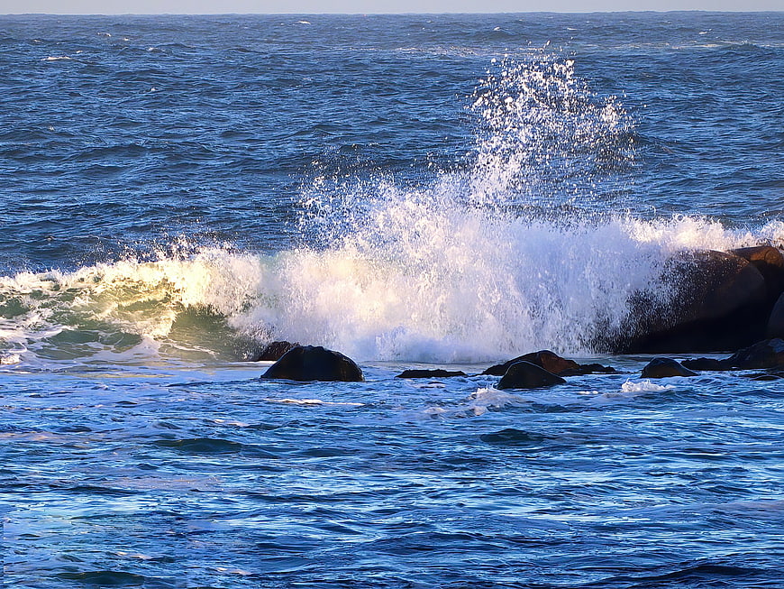 Powerful Ocean Wave Crashing Against Rocky Coastline
