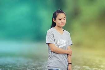Young woman in grey Nike t-shirt standing outdoors