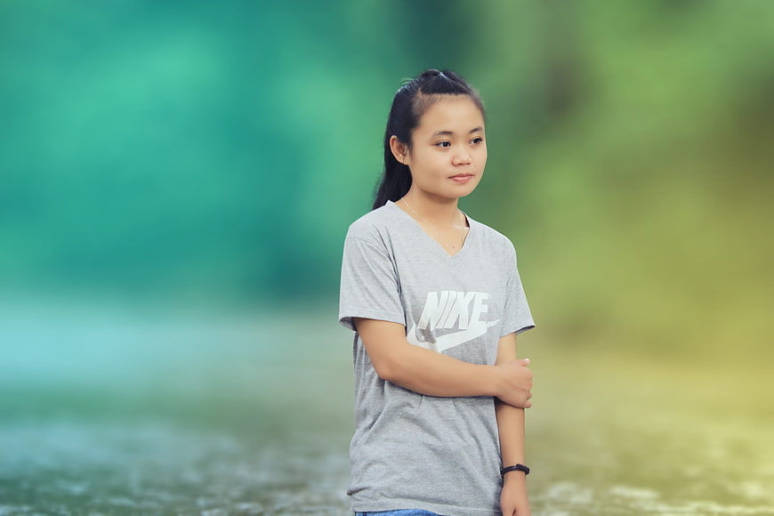 Young woman in grey Nike t-shirt standing outdoors