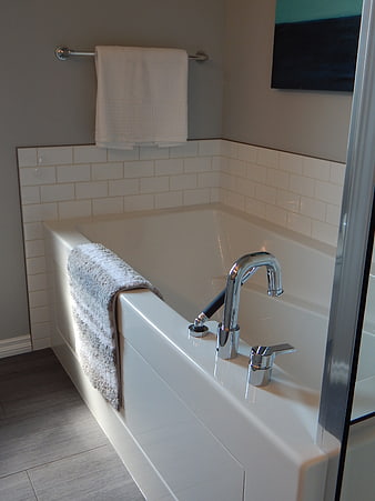 Modern White Bathtub With Chrome Faucet And Gray Towel