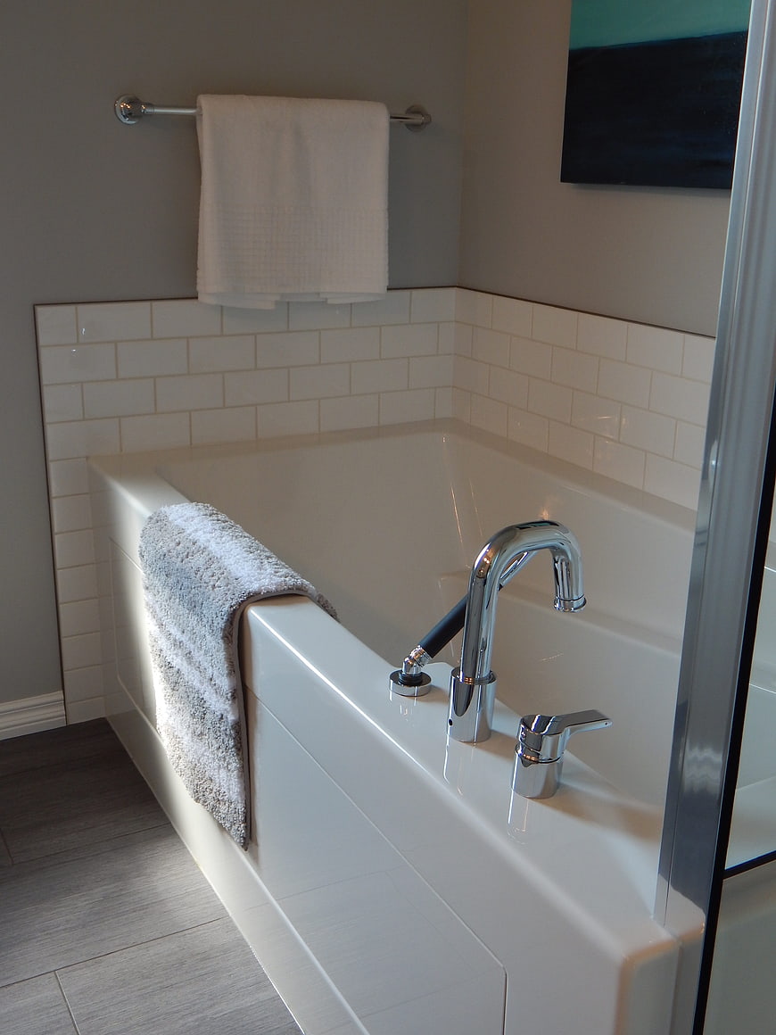 Modern White Bathtub With Chrome Faucet And Gray Towel