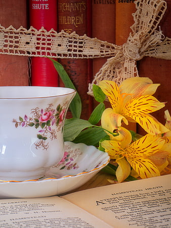 Vintage teacup with yellow flowers and old books