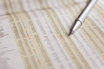 Silver pen on financial newspaper stock market data