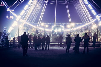 Silhouetted Crowd At Nighttime Christmas Market Ferris Wheel