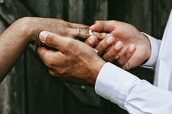Close-up of hands exchanging wedding rings