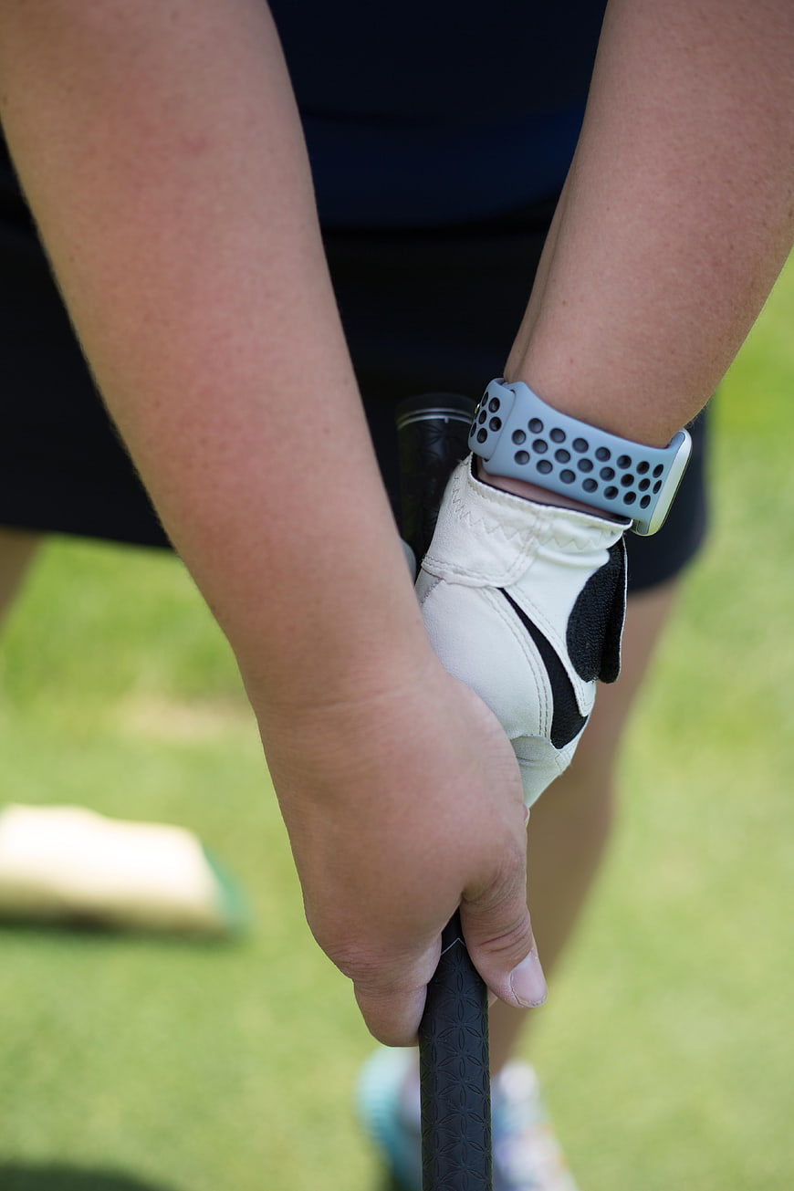Close-up of golfer's hands gripping club on green