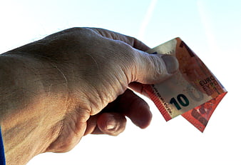 Hand holding ten euro banknote against white background