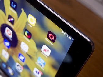 Close-up of Tablet Screen with App Icons on Wooden Desk