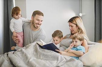 Happy family reading bedtime story together in bed