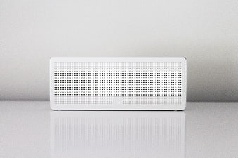Minimalist White Bluetooth Speaker on Reflective Surface